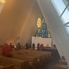 Inside the Arctic Cathedral, facing its massive triangular stained-glass window.