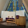 Inside the Arctic Cathedral, facing the massive triangular stained glass window and the altar.