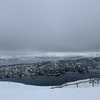 View from further along the ridge towards the city, out over a rather anaemic metal fence which was partially collapsed and partially buried in snow.